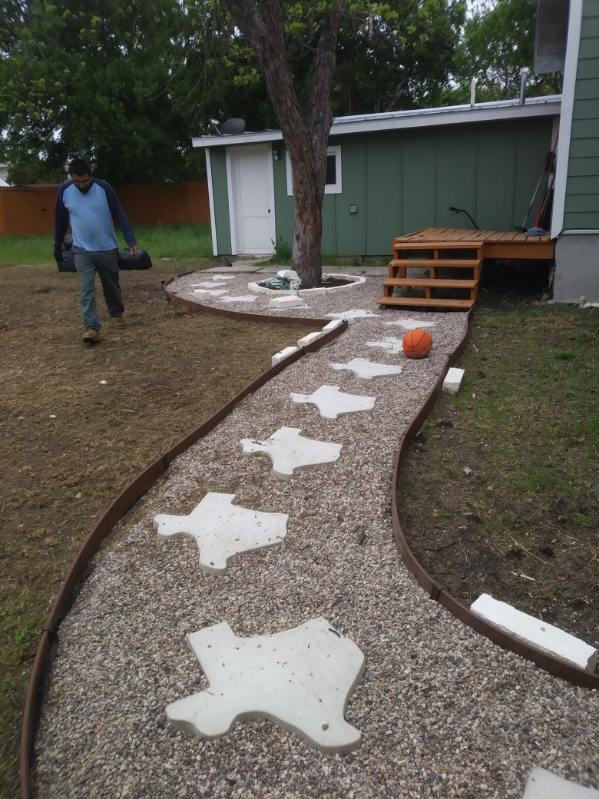 Completed curved gravel walkway with Texas-shaped stepping stones