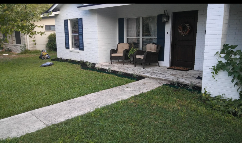 Completed front-yard landscape refresh with clean lawn and fresh mulch beds
